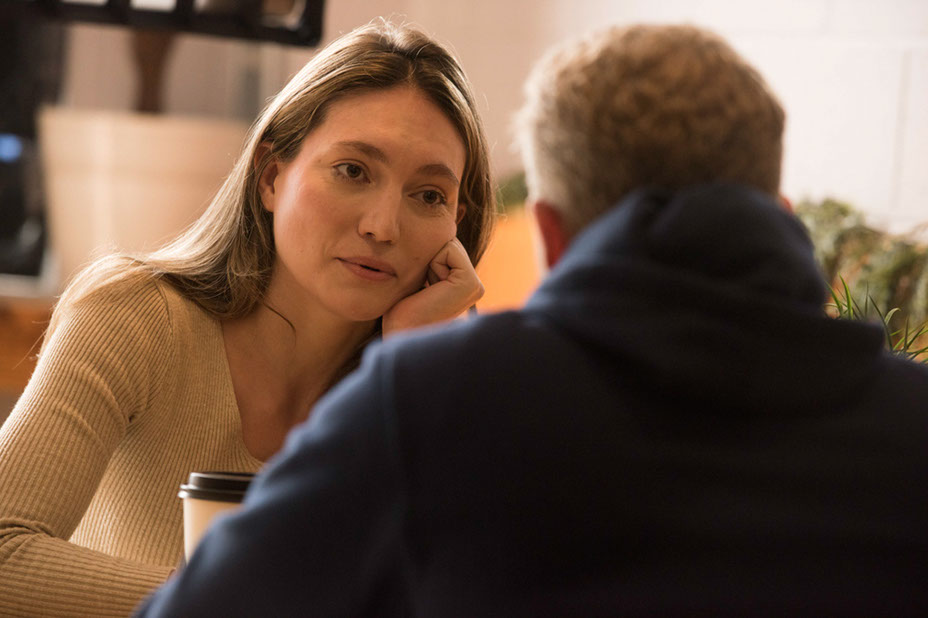 Amanda and Tommy in a warm-lit cafe.